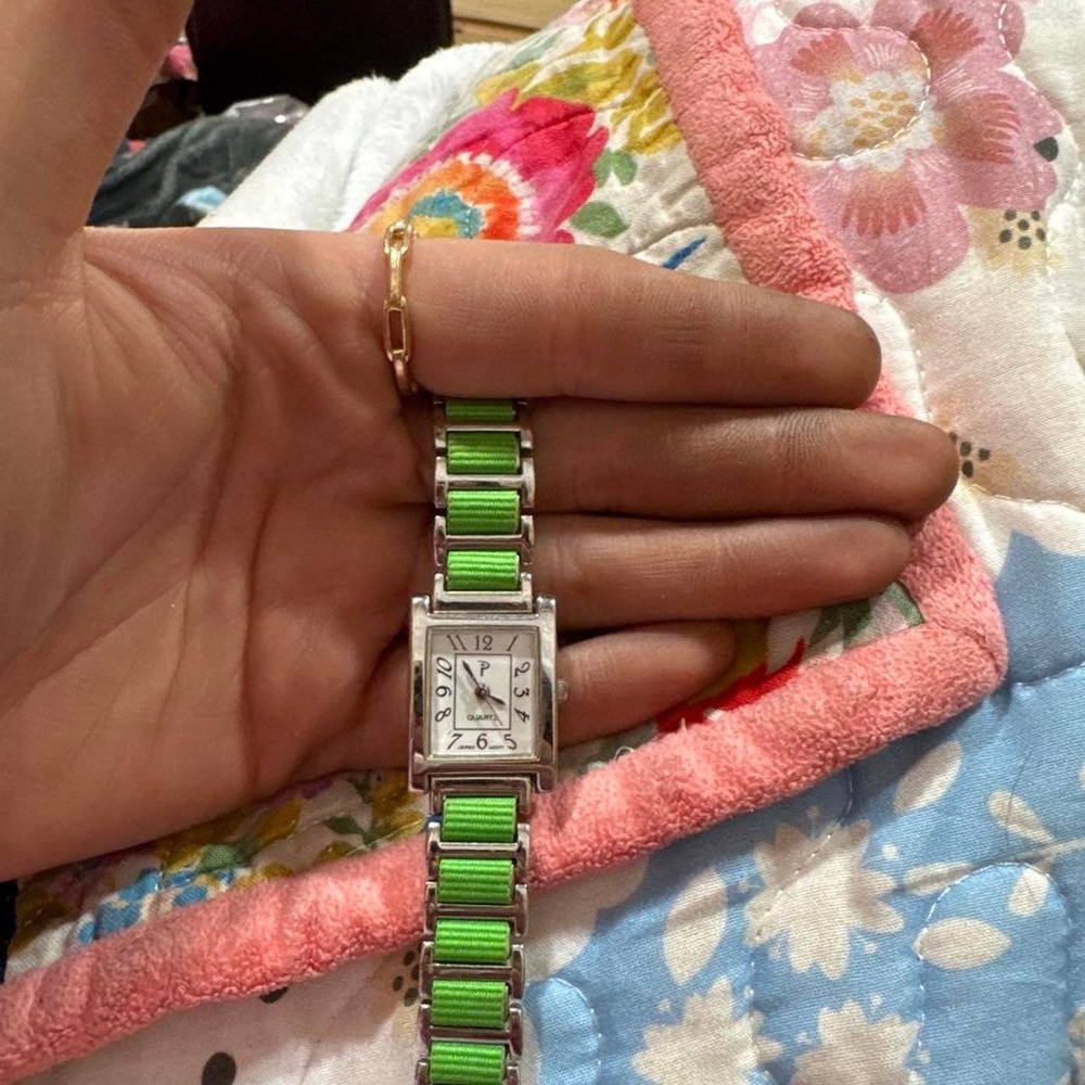 Green and silver rectangular watch with green striped band'